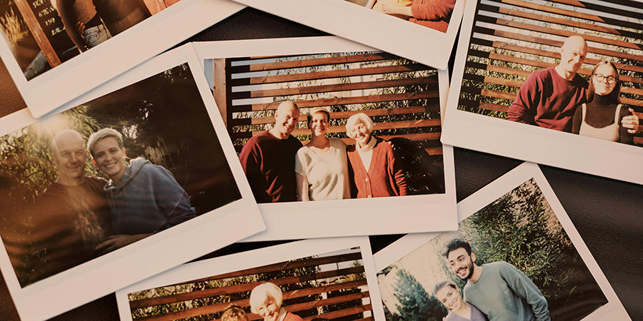Polaroid family photos spread across a table, showing portraits of multiple generations