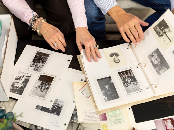 Two people turning the pages of vintage family photo albums together