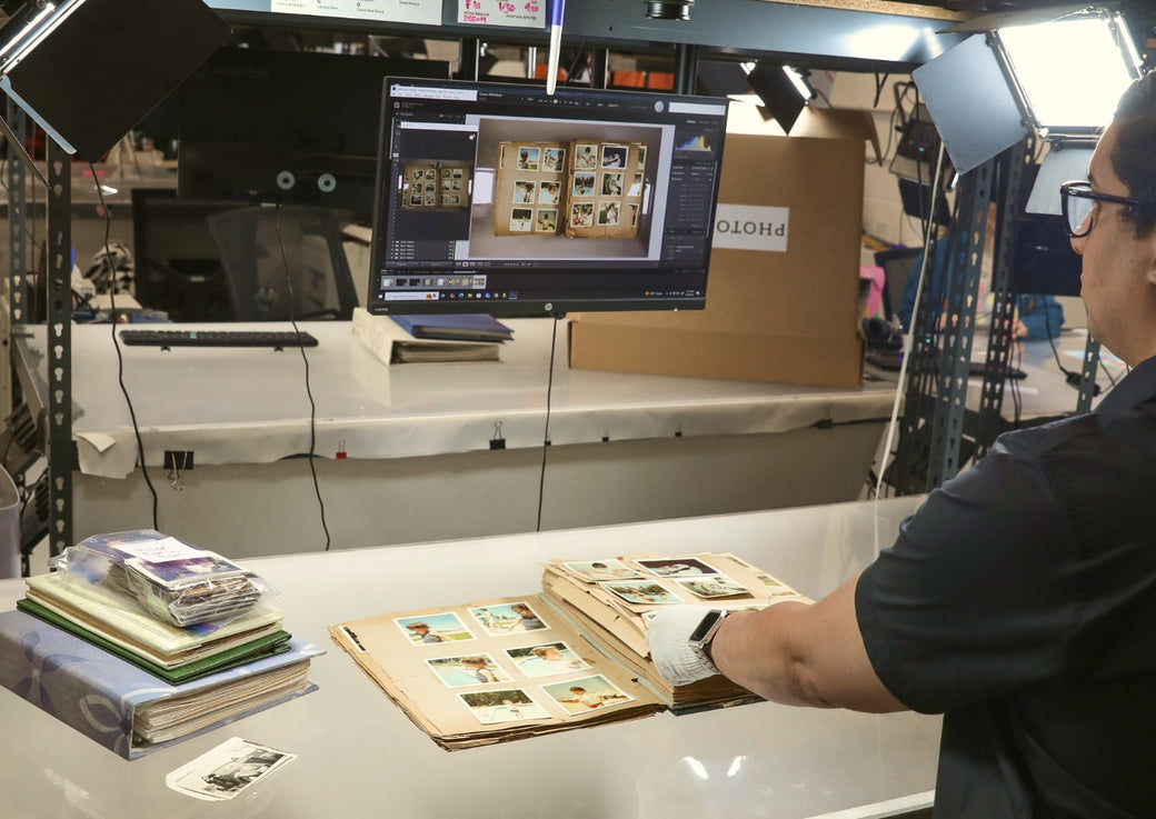 A Photokive archivist digitizing a vintage album at a professional lit photo-station