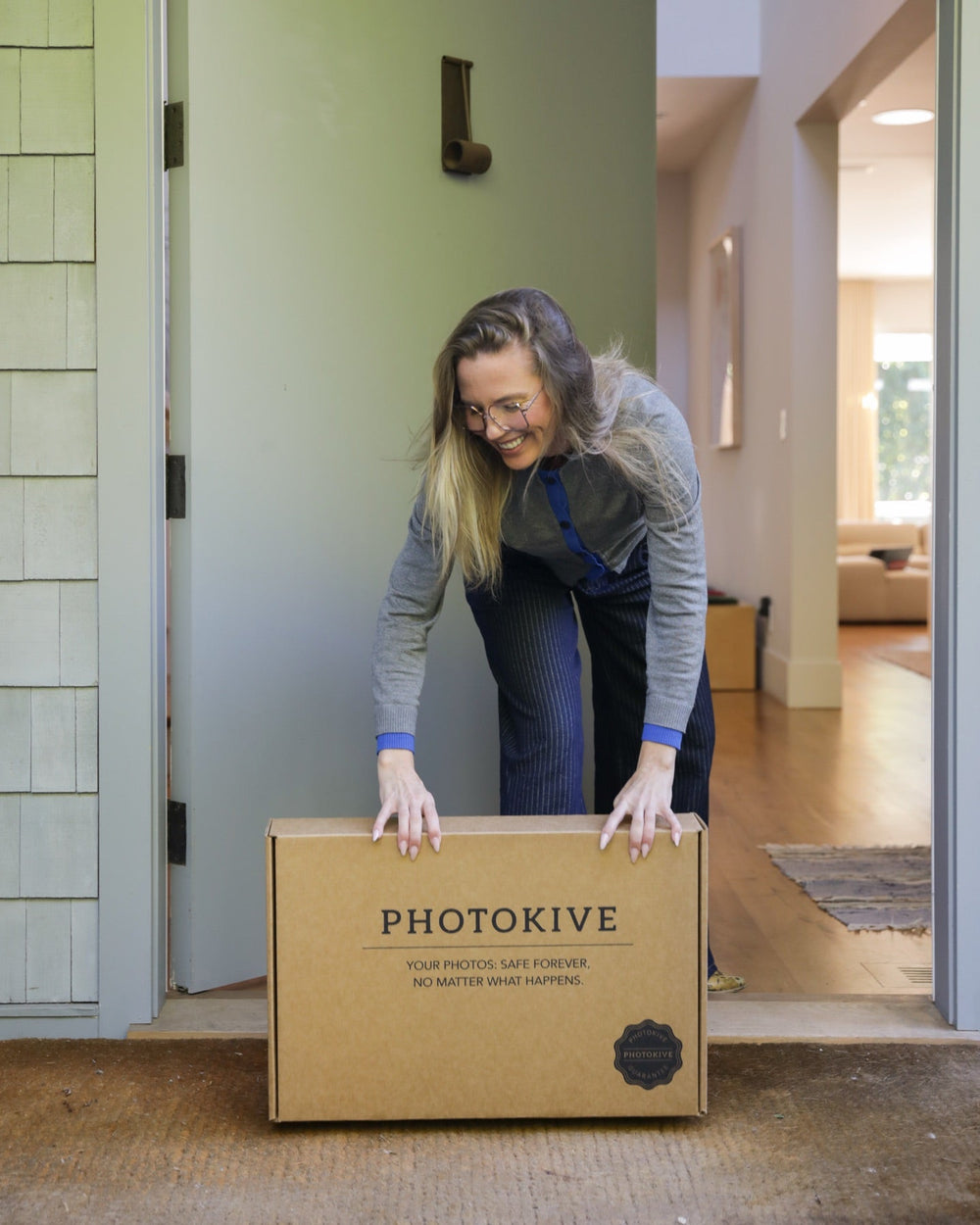 The Photokive Safekeeping Kit box open beside stacked family albums